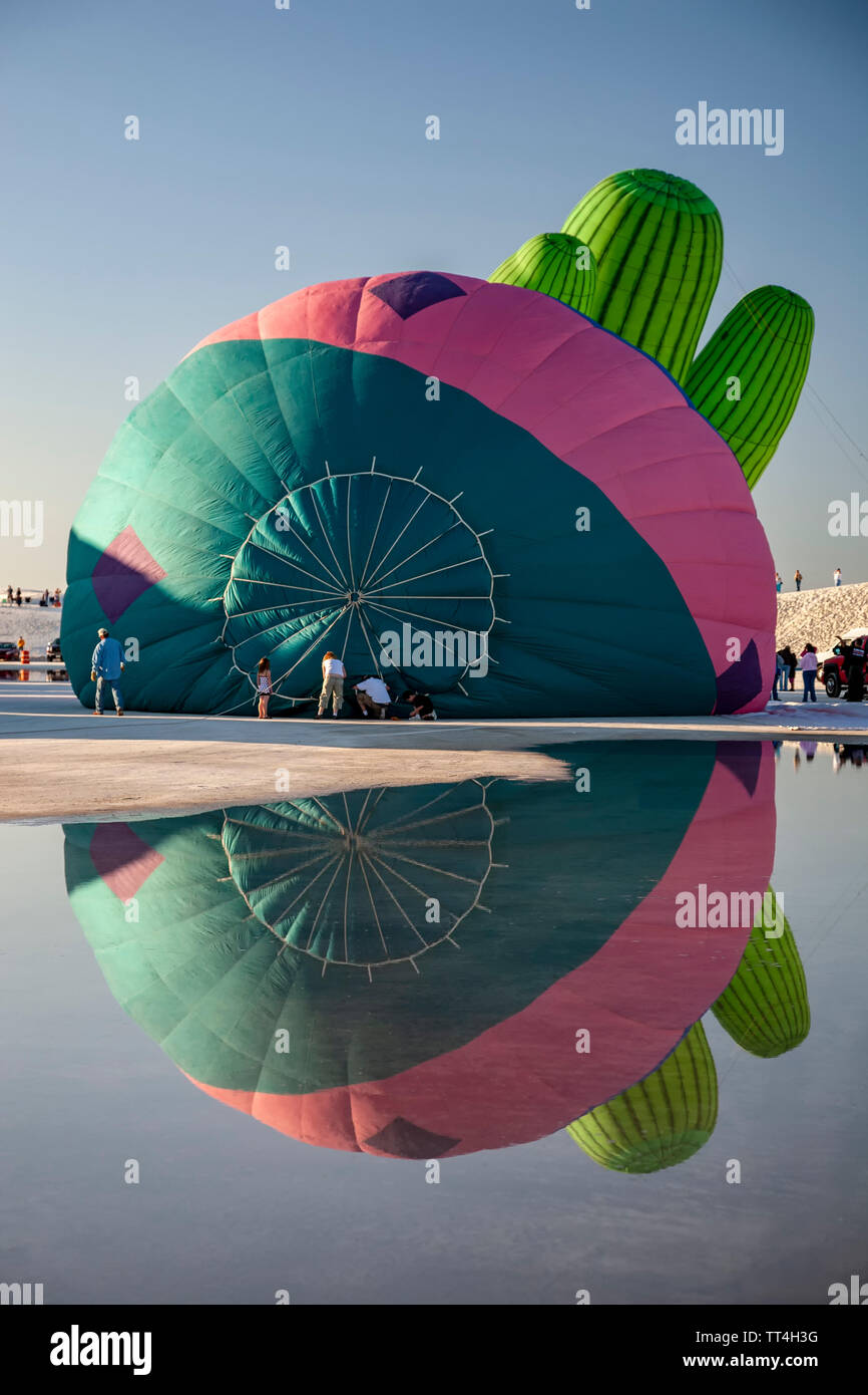 Hot air balloons reflected on puddle and people, White Sands Hot Air