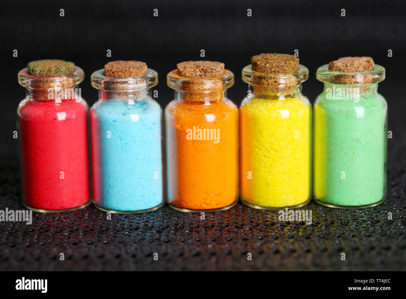 Bottles with colorful dry pigments on dark background Stock Photo - Alamy