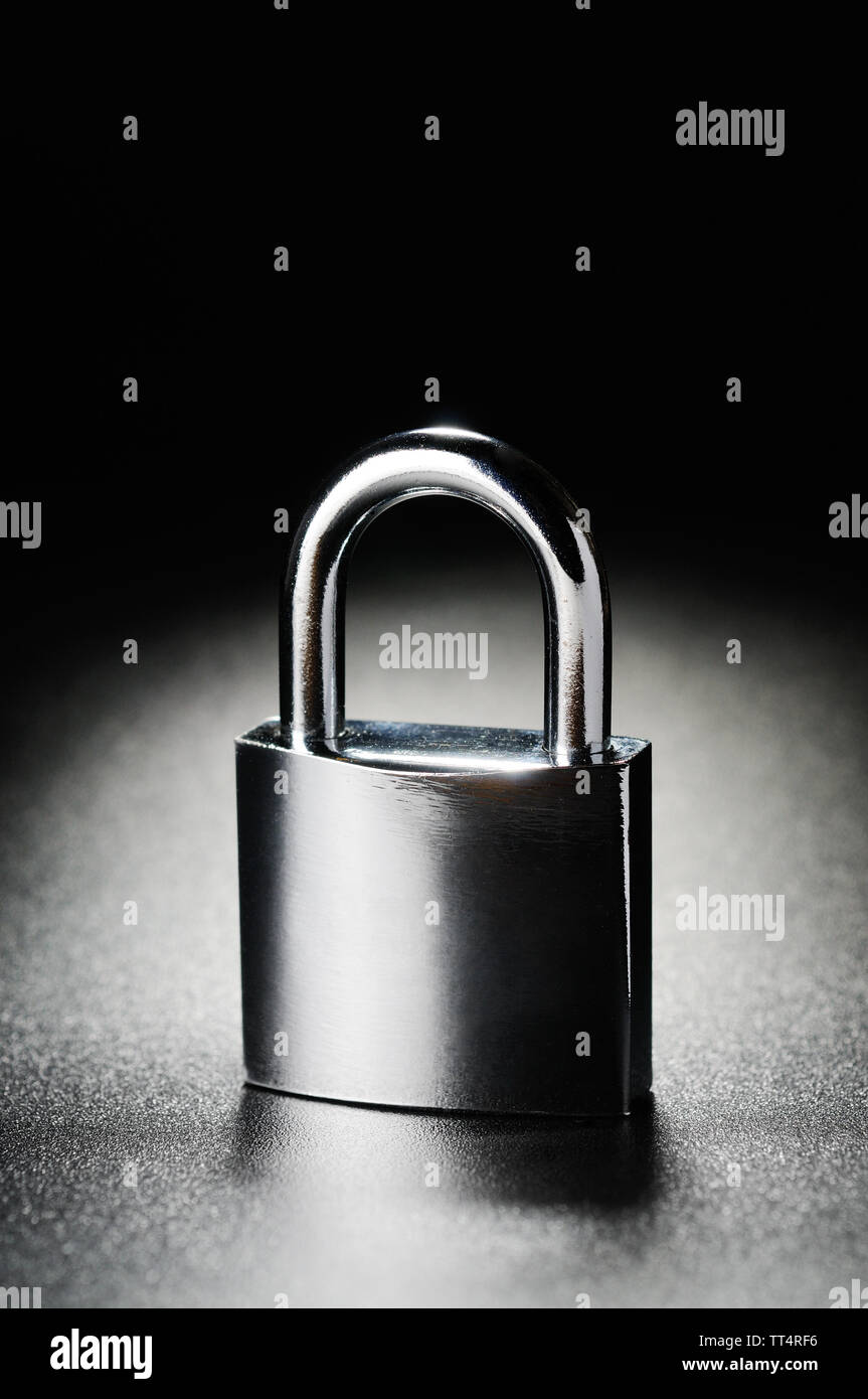 Steel padlock on the black textured background Stock Photo - Alamy