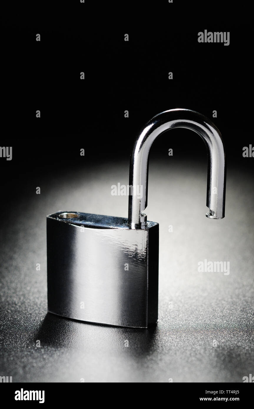 Steel padlock on the black textured background Stock Photo - Alamy