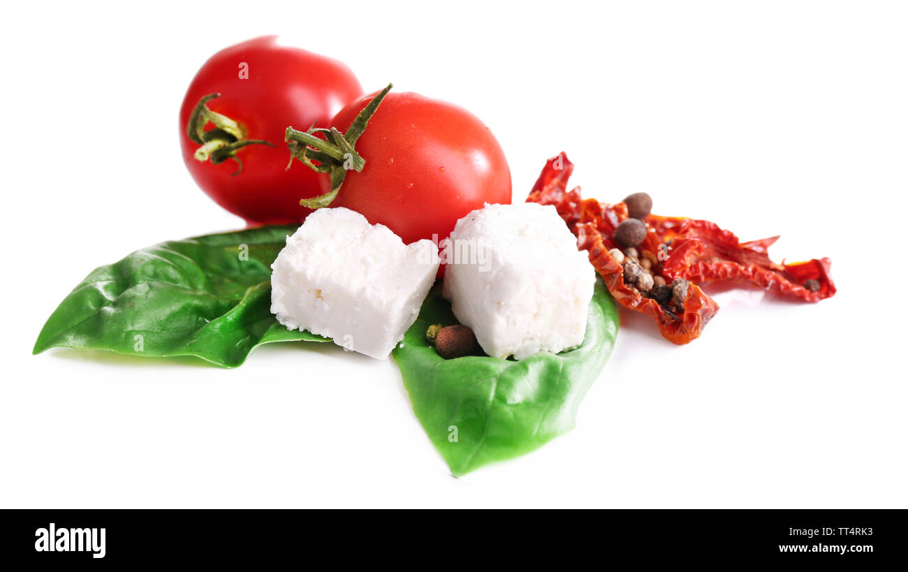 Sun dried tomatoes, feta cheese and basil leaves isolated on white