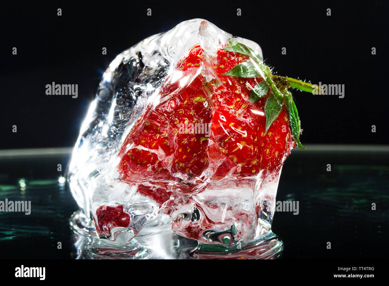 macro photo of fresh strawberry frozen in ice isolated on black ...