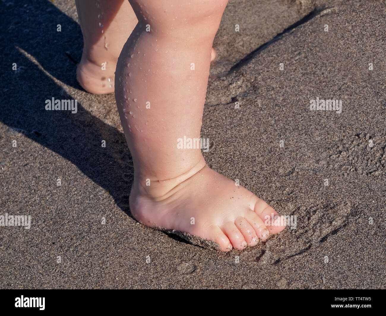 A young child's feet at the beach on the island of Key Biscayne, Florida, USA. Stock Photo