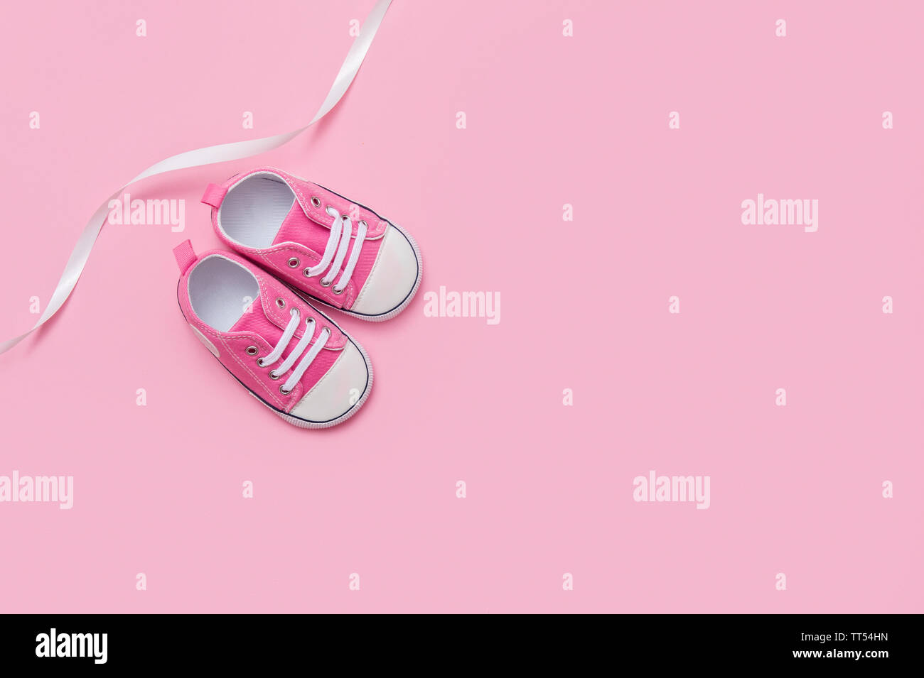 Cute pink baby girl sneakers close up on pink background Stock Photo