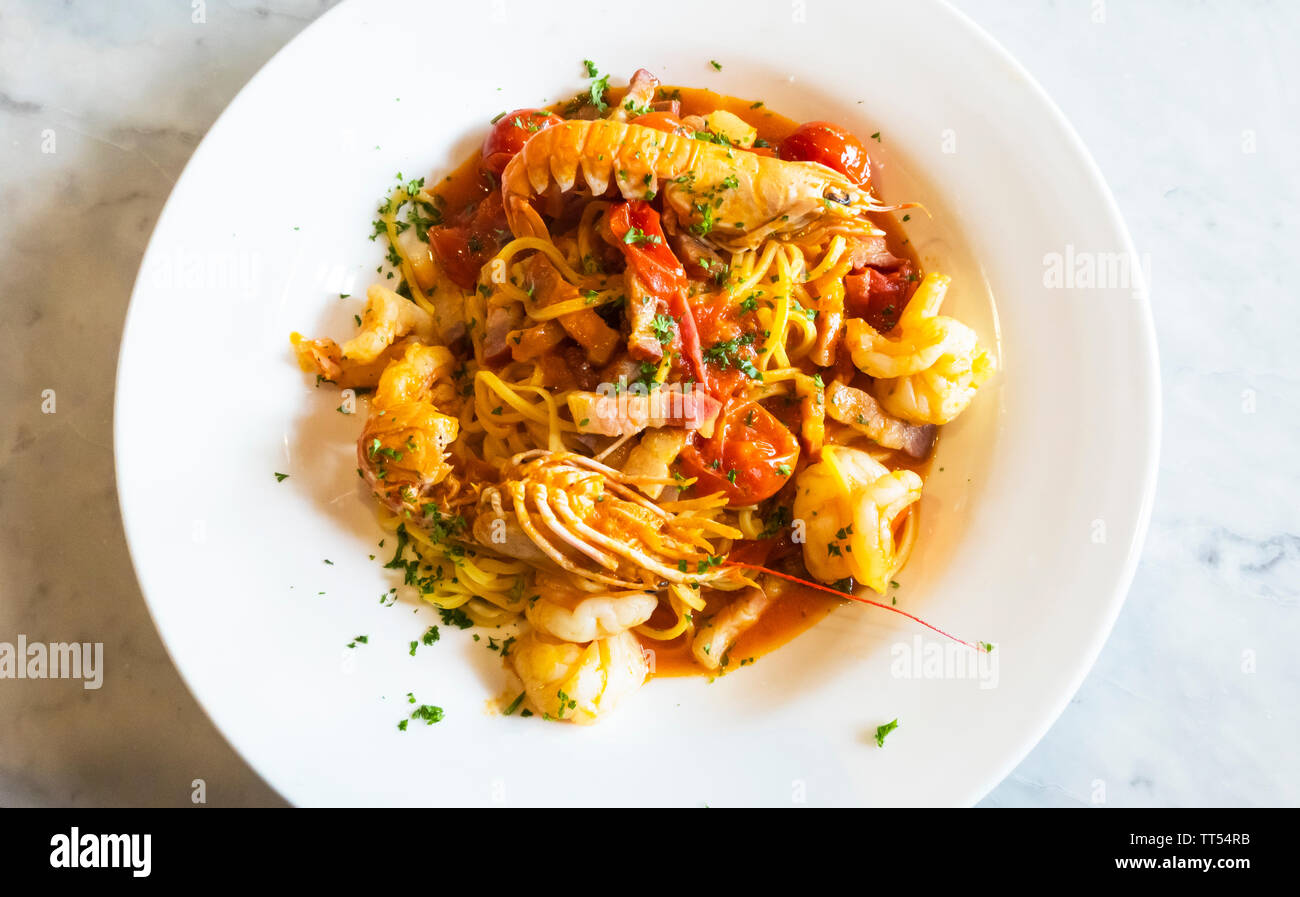 Spaghetti with seafood, bacon, and fresh tomatoes Stock Photo