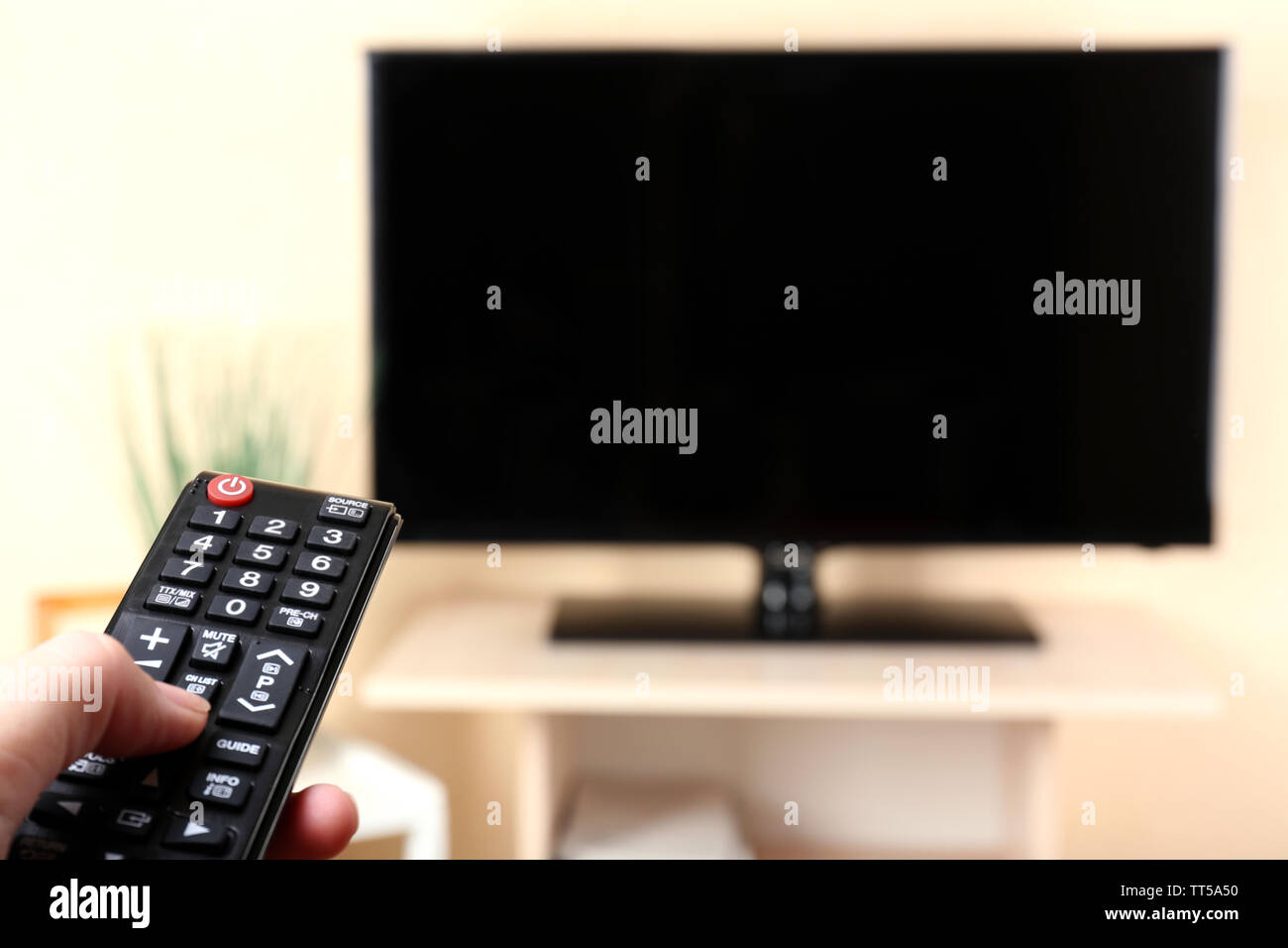 Watching TV and using remote controller Stock Photo - Alamy