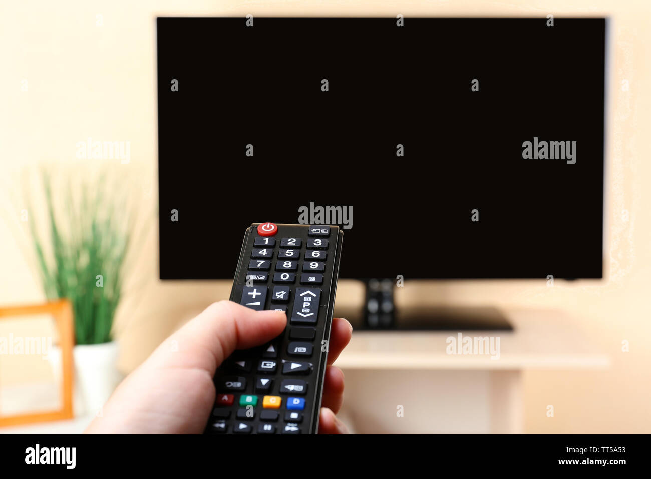 Watching TV and using remote controller Stock Photo - Alamy