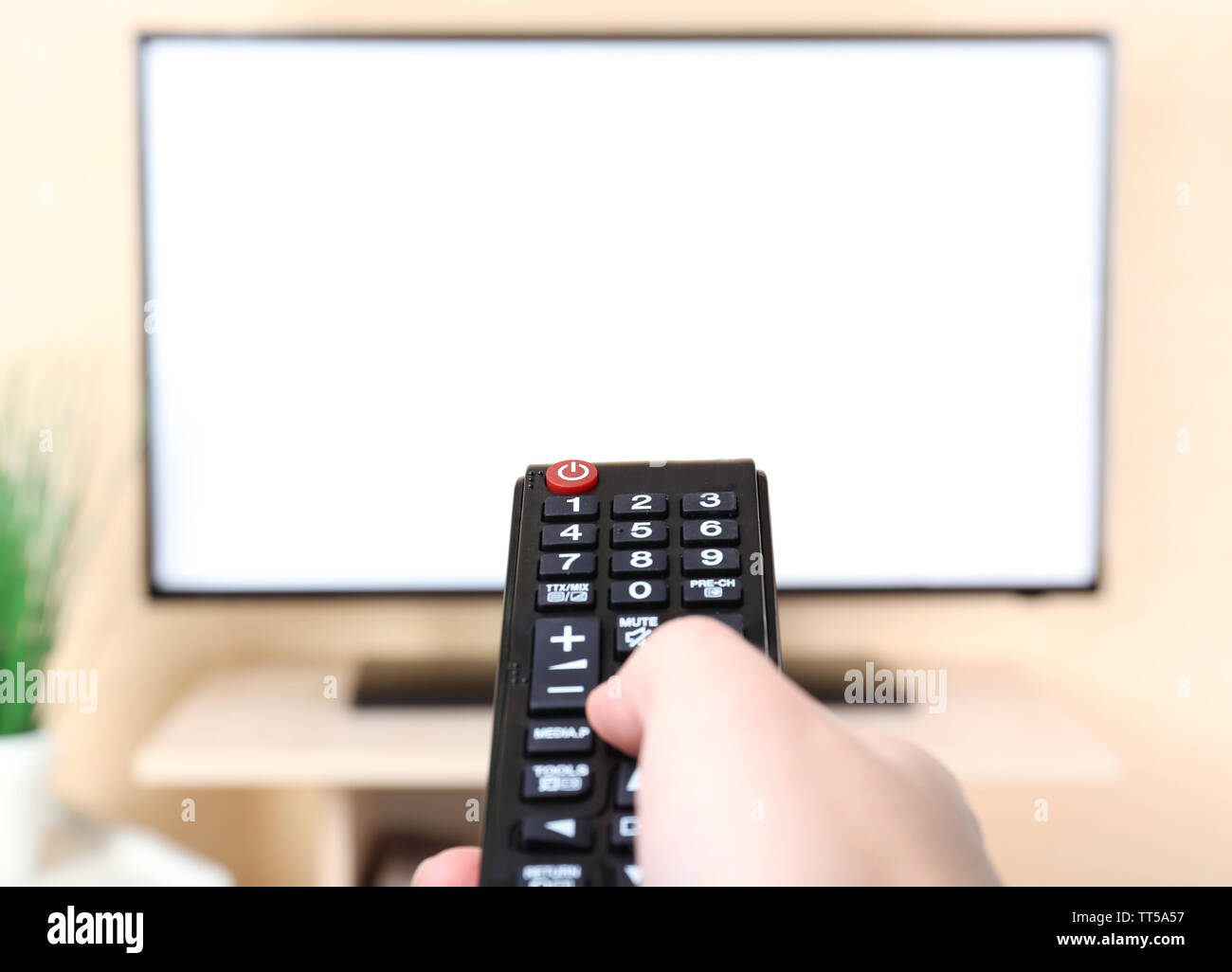 Watching TV and using remote controller Stock Photo - Alamy