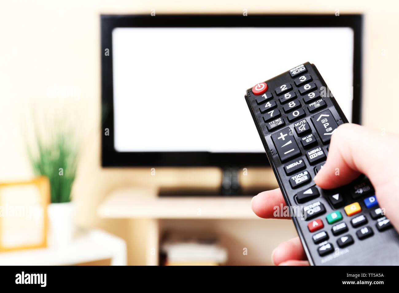 Watching TV and using remote controller Stock Photo - Alamy