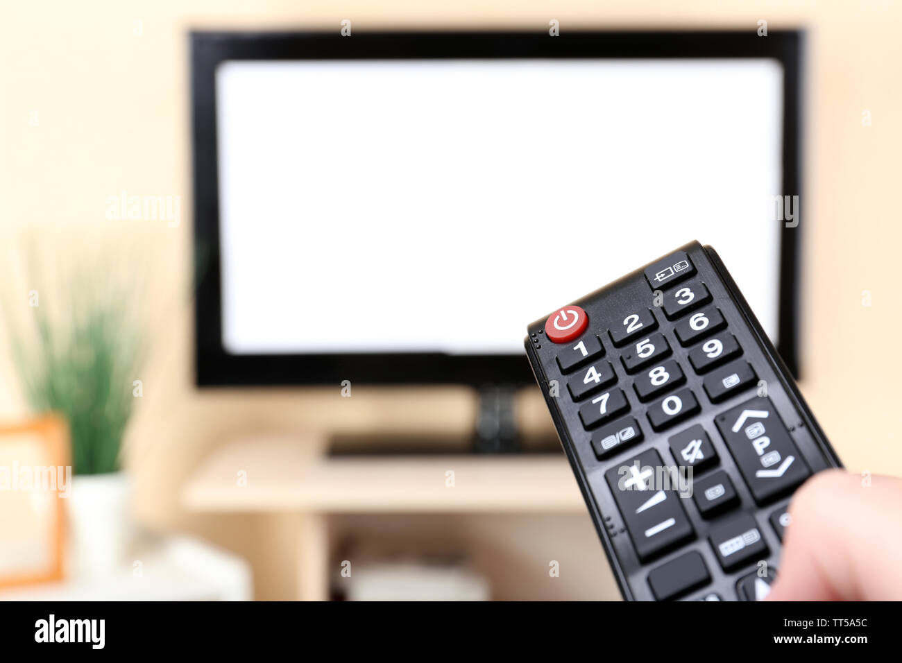 Watching TV and using remote controller Stock Photo - Alamy
