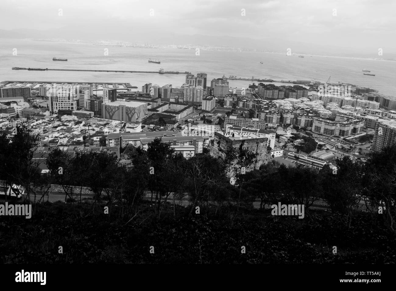 Gibraltar harbour from the rock view views water sea football ground boats boat Morocco town city flats tall buildings trees road landscape view view Stock Photo