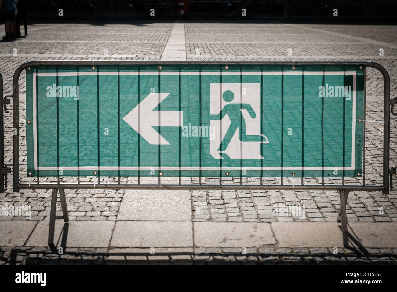 emergency exit sign on security fence for outdoor event Stock Photo