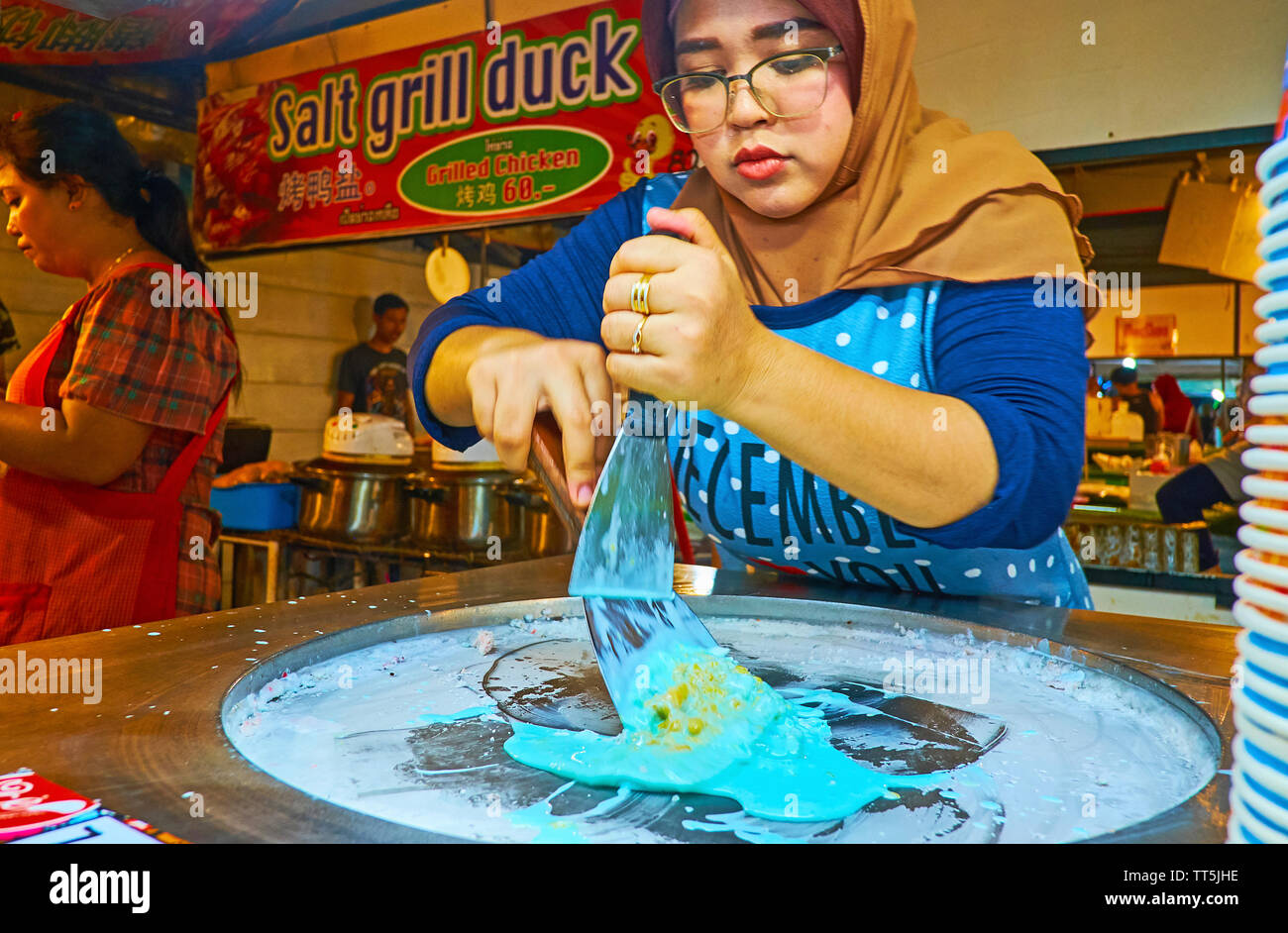 AO NANG, THAILAND - APRIL 27, 2019: The cook prepares blue lemon dondurma ice cream (ice rolls) in food stall of Night Bazaar, on April 27 in Ao Nang Stock Photo