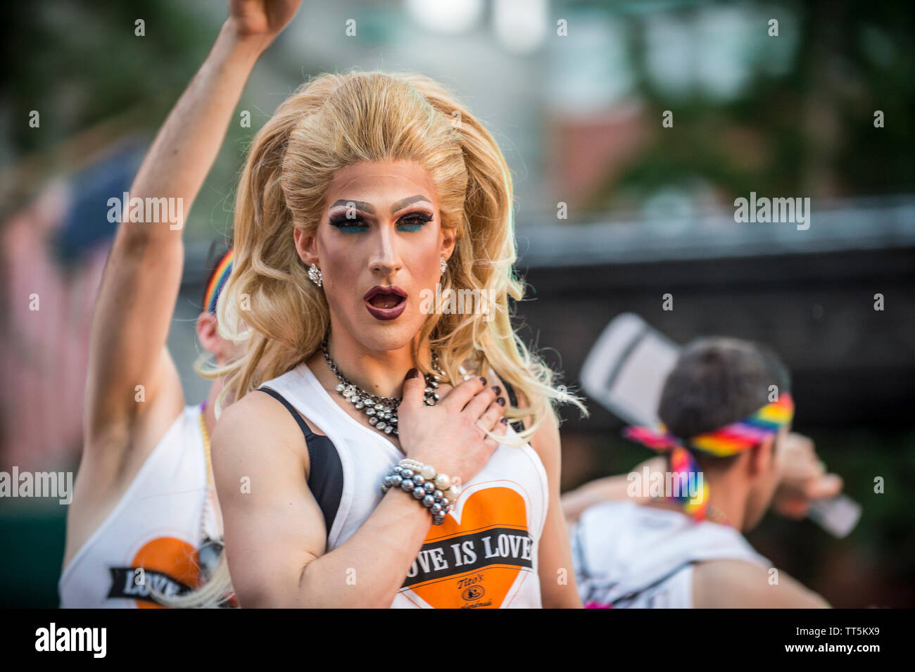 NEW YORK CITY - JUNE 25, 2017: A transgender drag performer with big hair wears a 'Love is Love' T-shirt on a float in the annual gay pride parade. Stock Photo