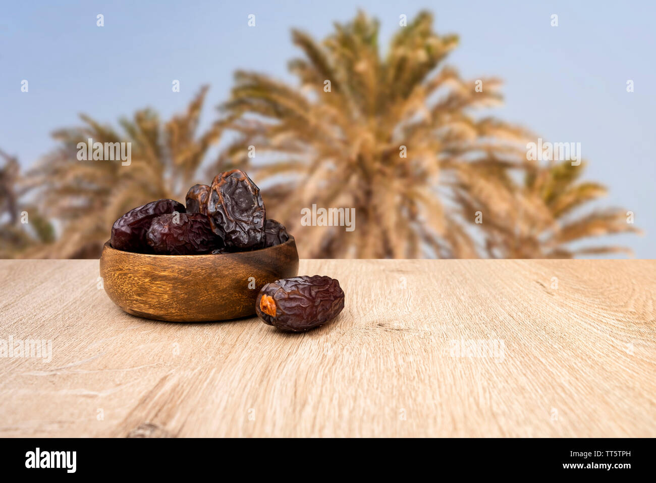 Dates fruit in bowl, background is date fruit tree Stock Photo