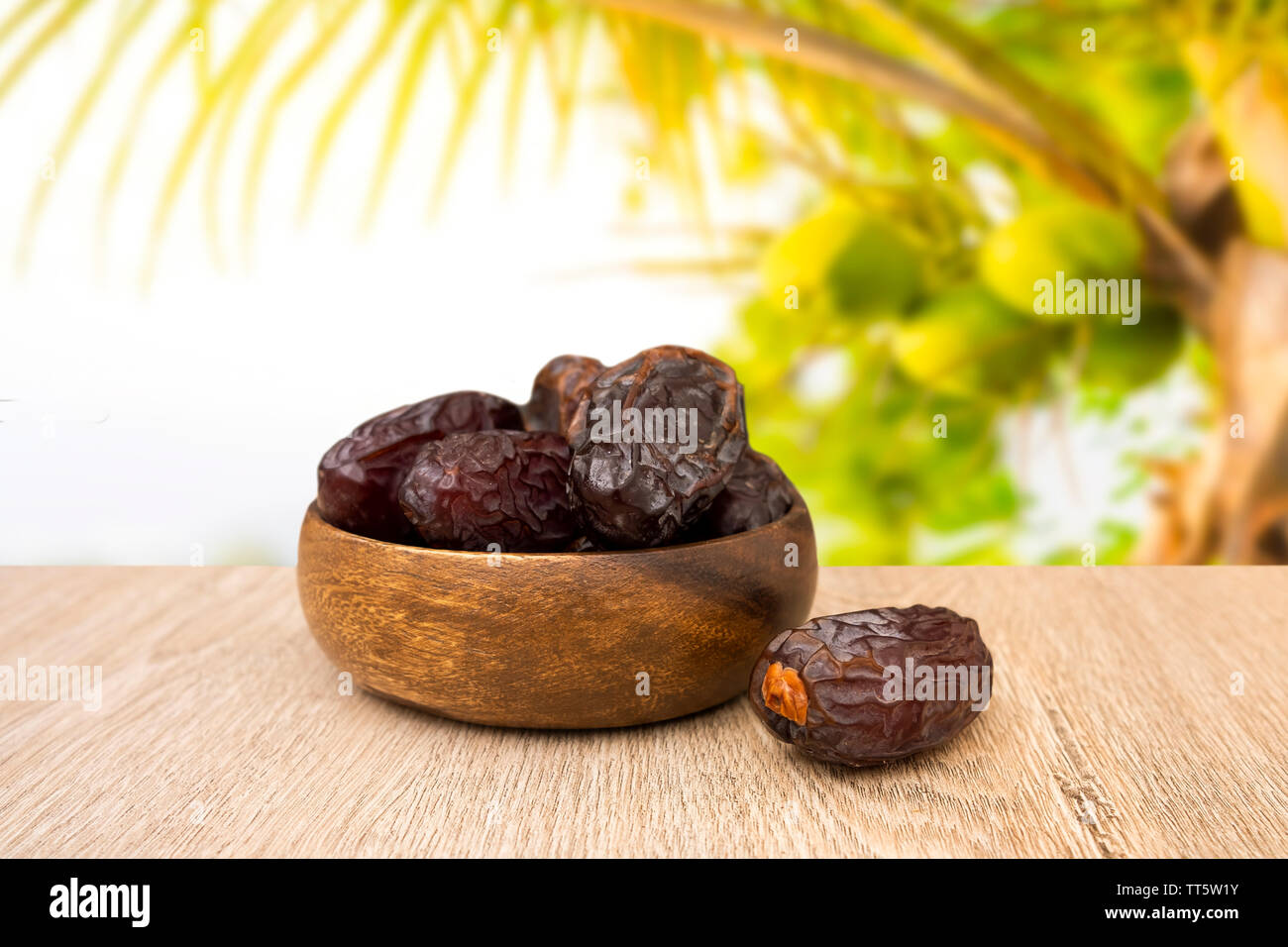 Dates fruit in bowl, background is date fruit tree Stock Photo