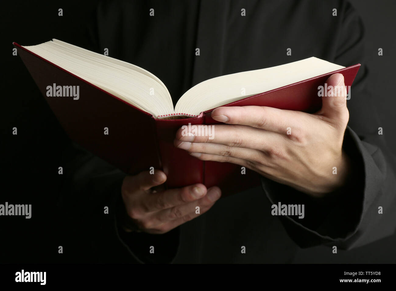 Man holding Bible on dark background Stock Photo
