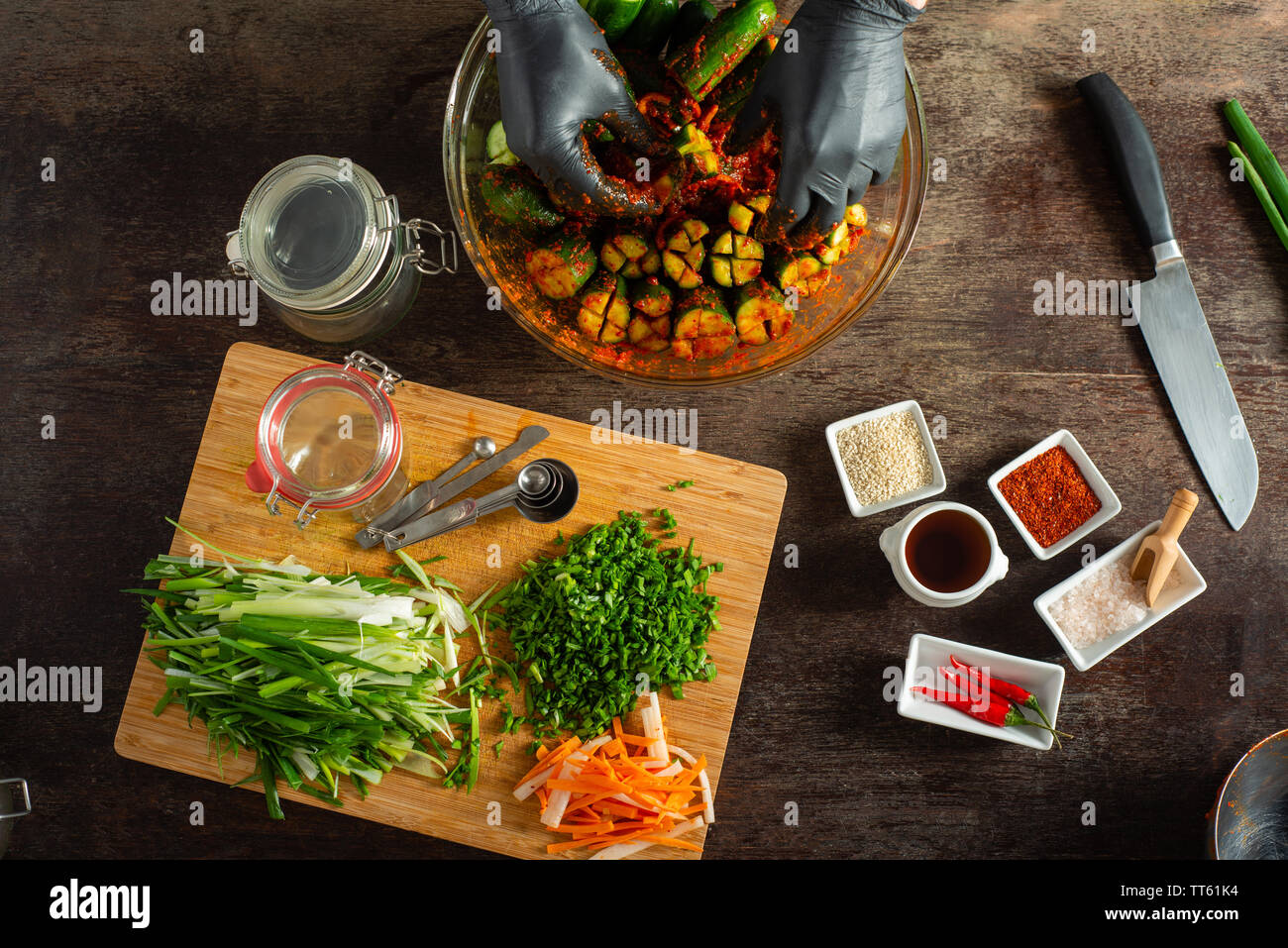 Various food items and ingredients for making spicy kimchee a favorite healthy fermented Korean condiment. Colorful and delicious. Hands preparing. Stock Photo