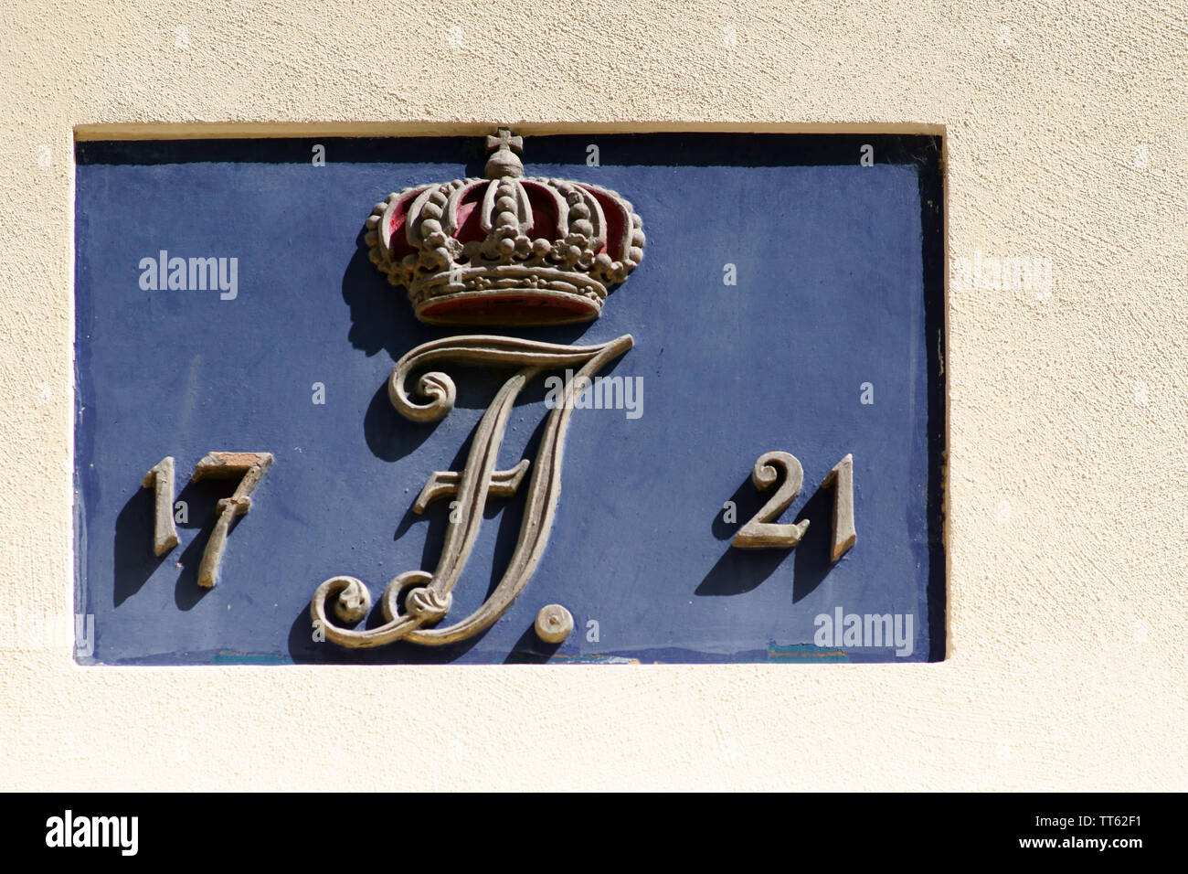 The detail of a landmarked residential building with the year of construction and a crown as a symbol. Stock Photo