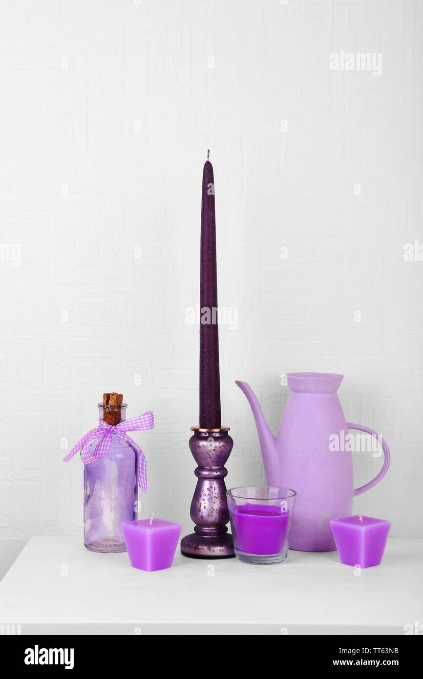 Candles in candle holders on table on white background Stock Photo - Alamy