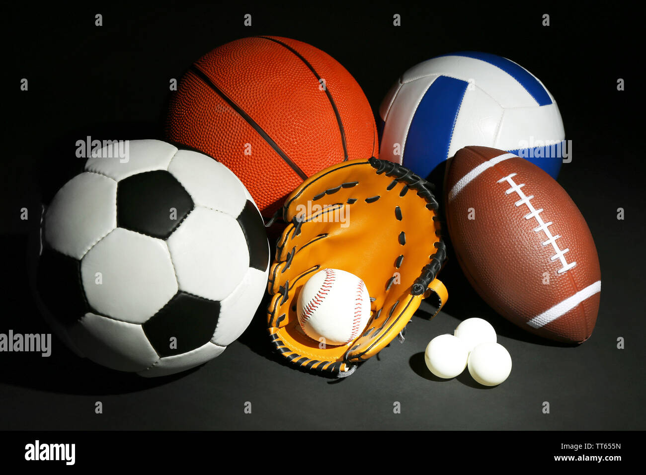 Sports balls on black background Stock Photo - Alamy