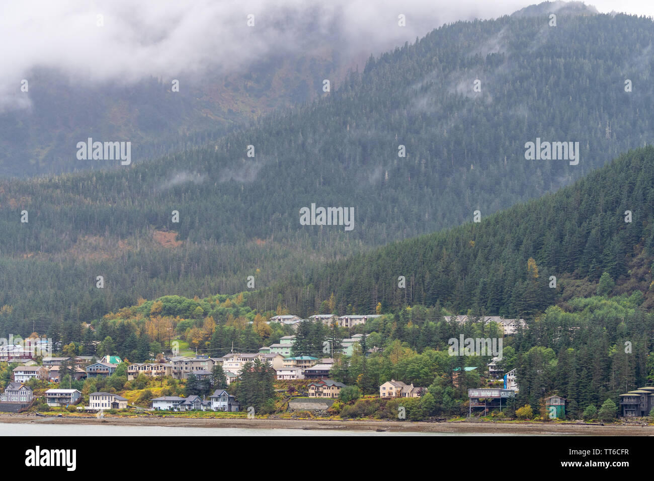 Scenic mountain landscapes in Juneau, Alaska. Community of homes/houses and large commercial office buildings and schools at the foot of the mountain. Stock Photo