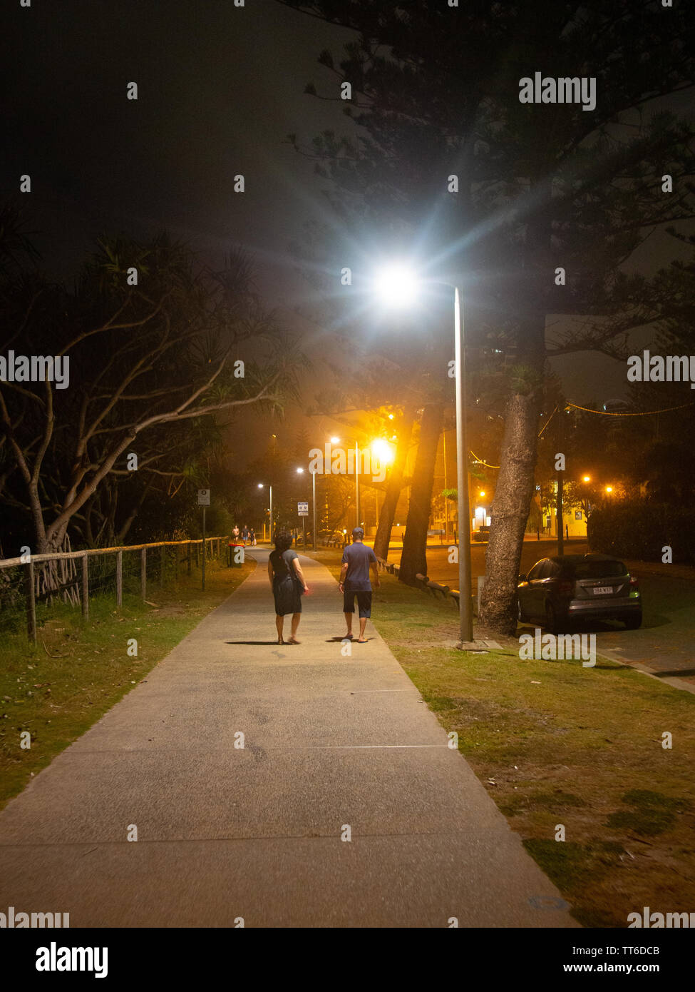 People Out For A Night Time Walk Under A Street Light Stock Photo Alamy