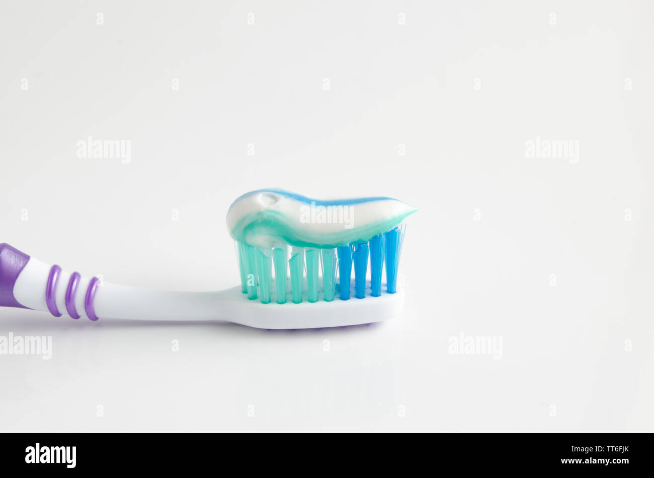 Toothpaste squeezed on the toothbrush on white background Stock Photo