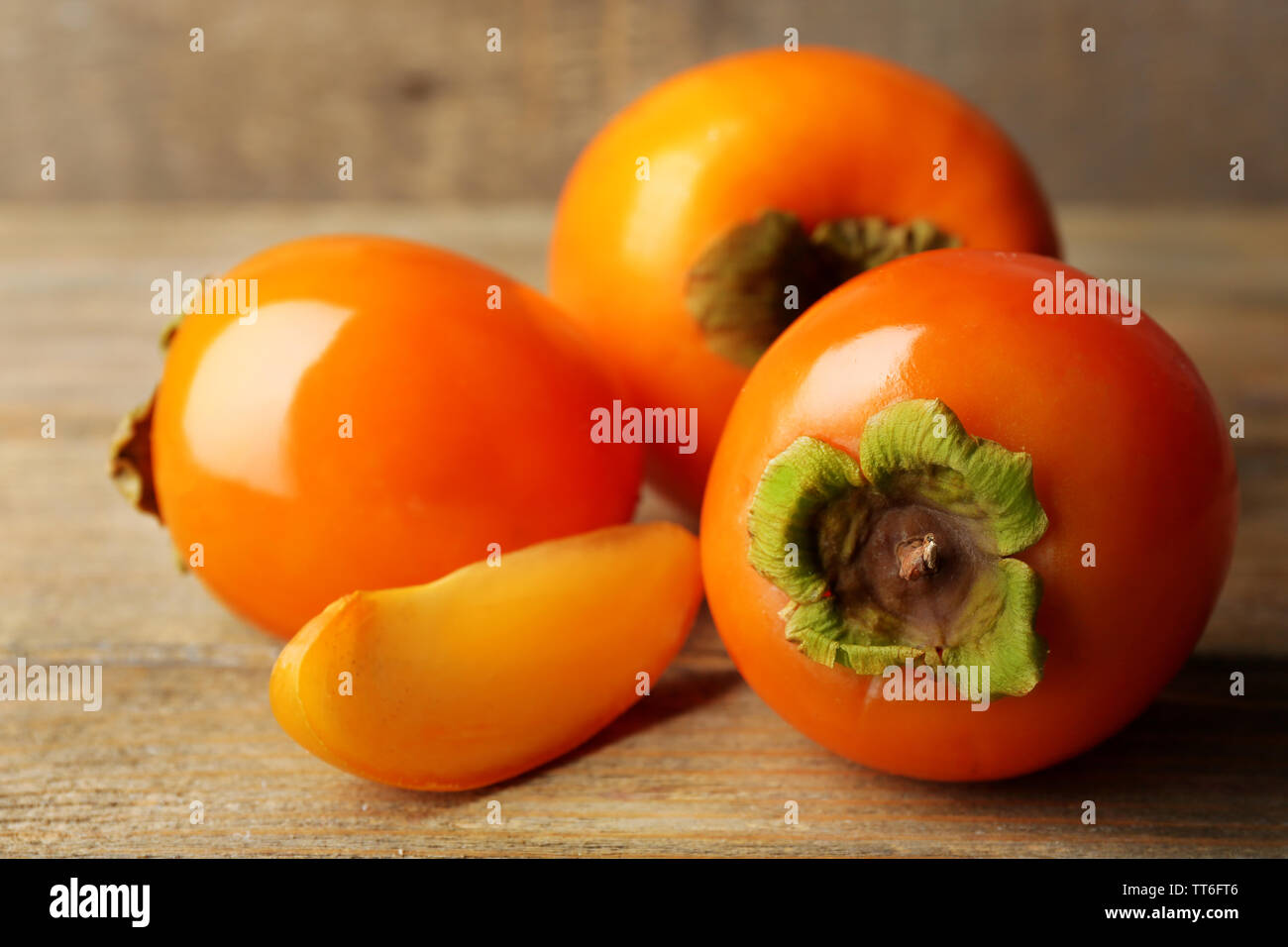 Ripe persimmon on color wooden background Stock Photo - Alamy
