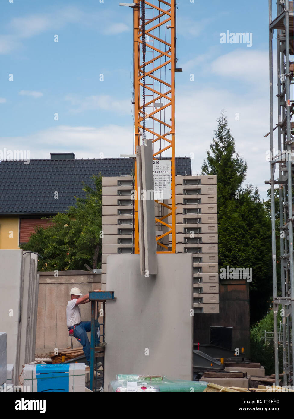 Neuwied, Germany - June 14, 2019: a construction worker in front of a crane supporting the lifting of a prefabricated component Stock Photo