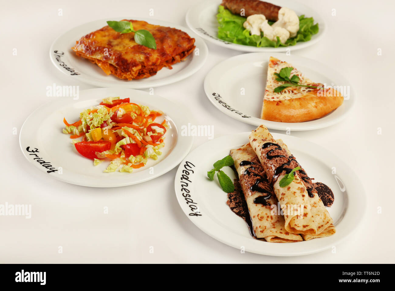 Daily menu. Plates with food on table Stock Photo - Alamy
