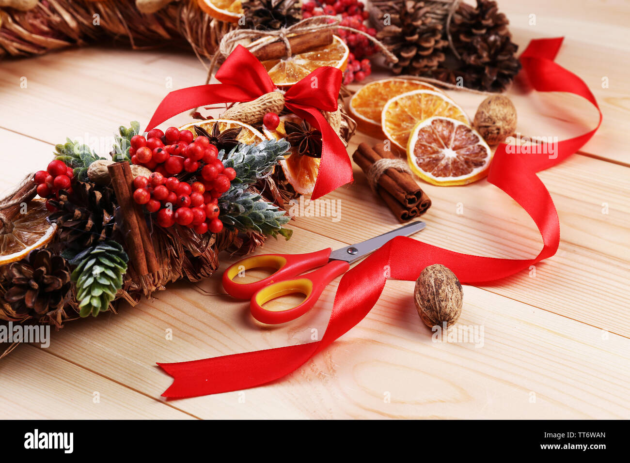 Christmas wreath with materials for decorating on wooden background