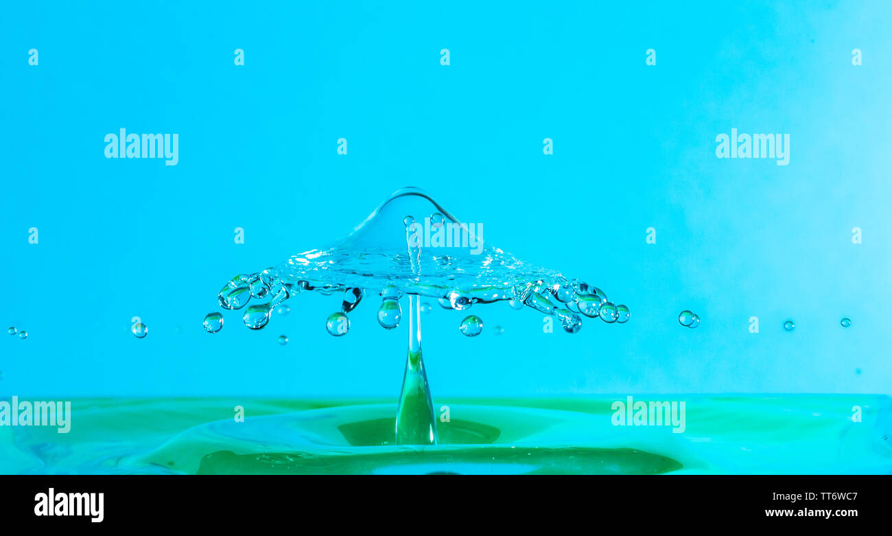 water drop falling and impacting a body of water after hitting the