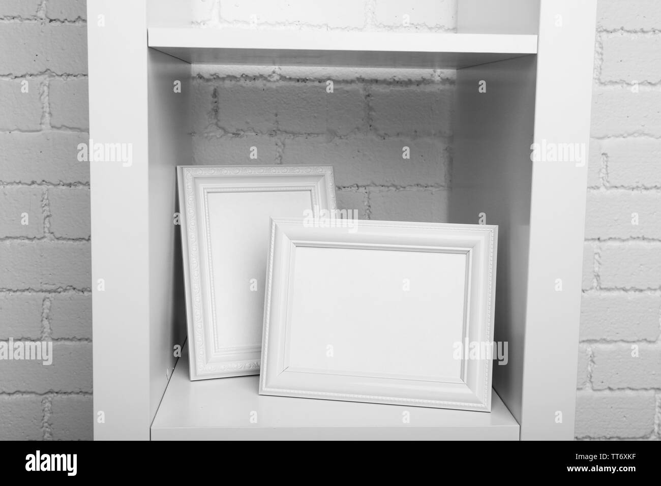 Photo frames on shelf on brick wall background Stock Photo