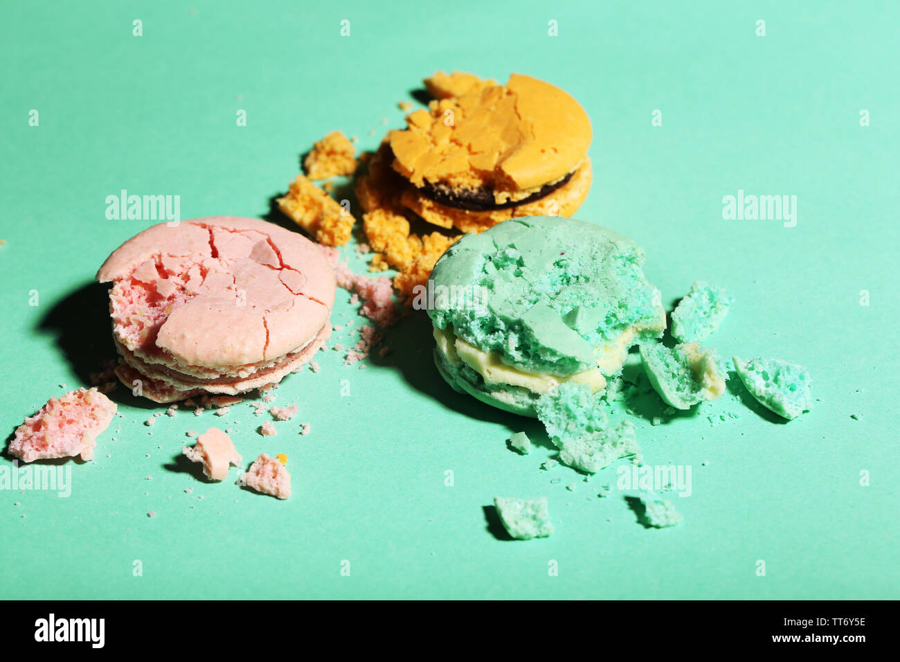 Bright tasty broken macaroons cakes on color background Stock Photo