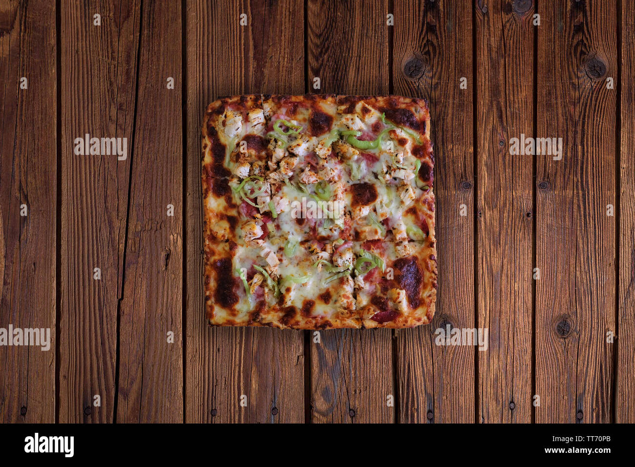 Square pizza on wooden table, top view of square sliced pizza Stock Photo