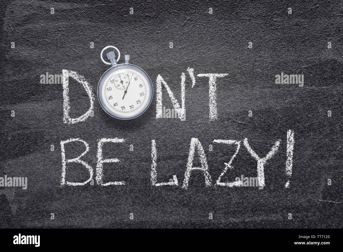 don’t be lazy phrase handwritten on chalkboard with vintage precise stopwatch used instead of O Stock Photo