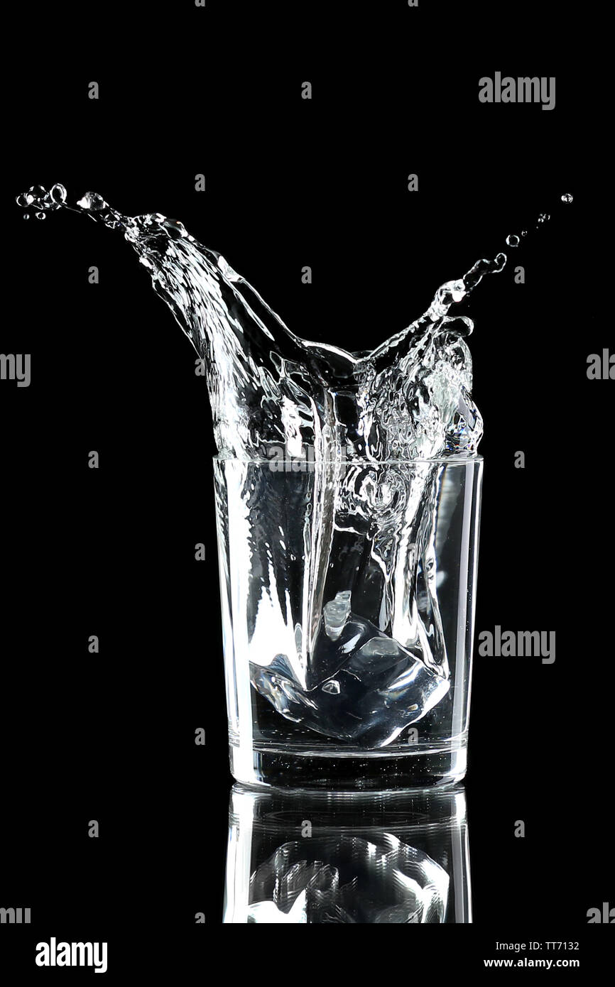 Water splash with ice in glass isolated on black Stock Photo - Alamy
