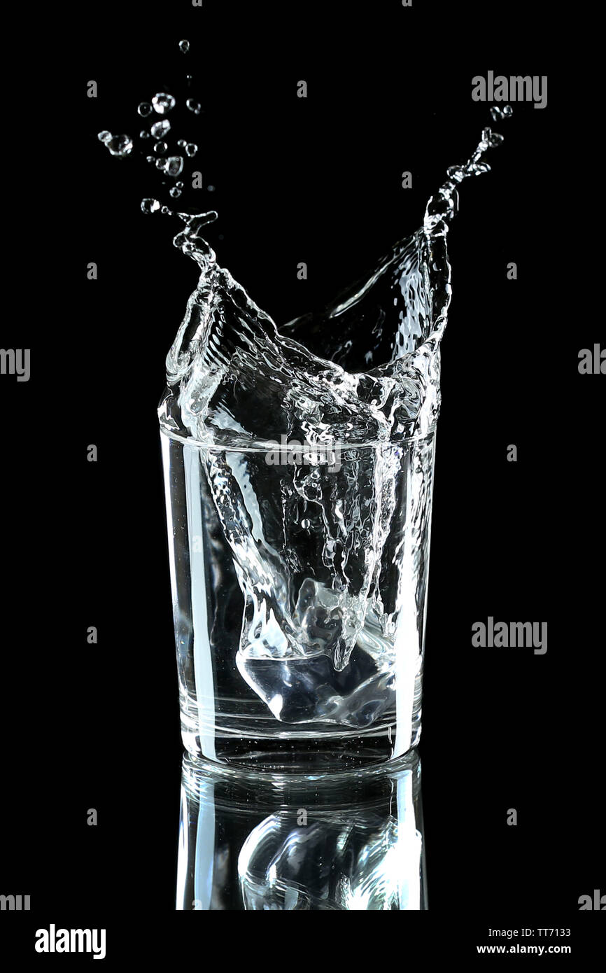Water splash with ice in glass isolated on black Stock Photo - Alamy