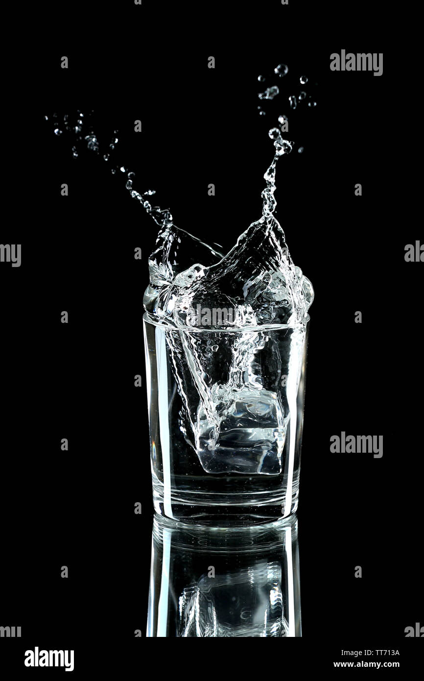 Water splash with ice in glass isolated on black Stock Photo - Alamy