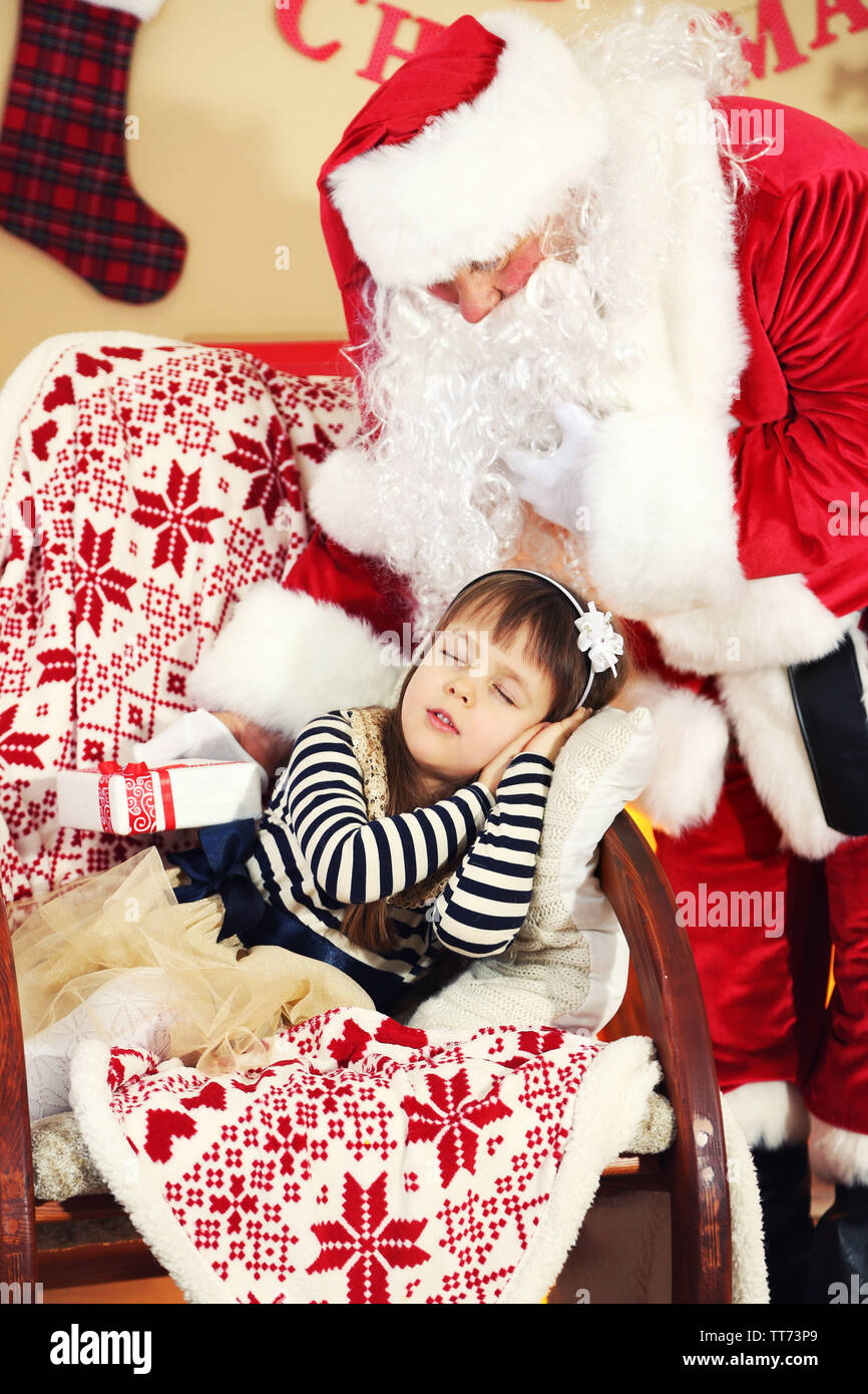 Santa Claus giving present to sleeping little cute girl Christmas tree ...