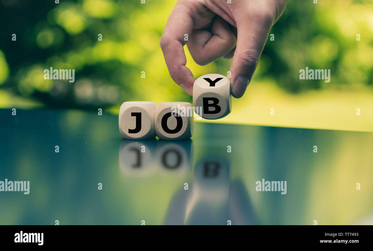 Concept for fun at work. Hand turns a cube and changes the word "job" to "joy". Stock Photo