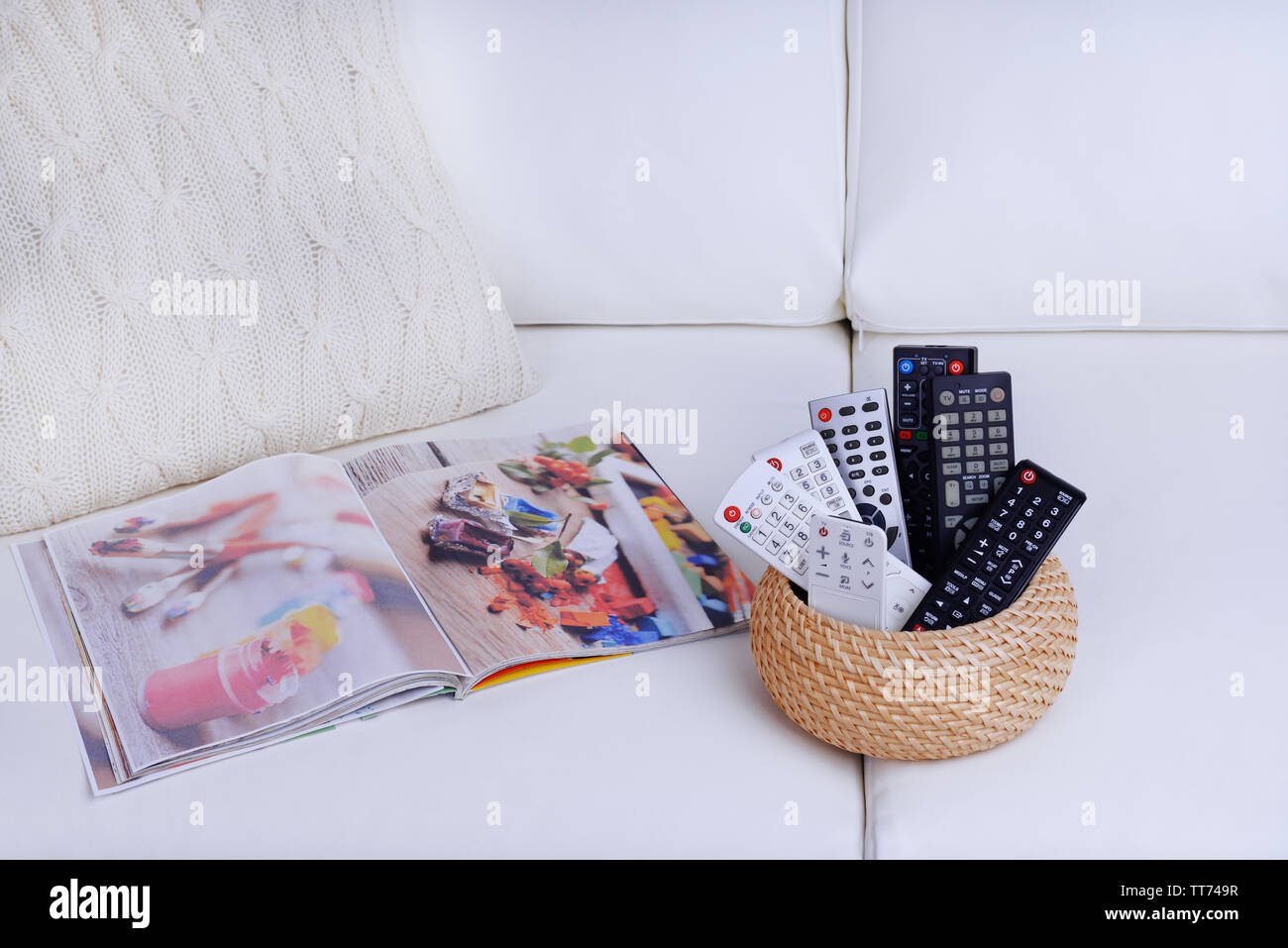 Many remote control devices on sofa Stock Photo