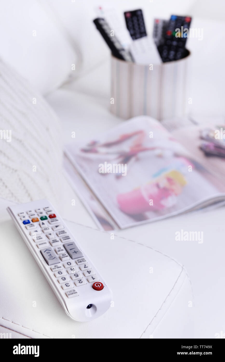 Many remote control devices on sofa Stock Photo