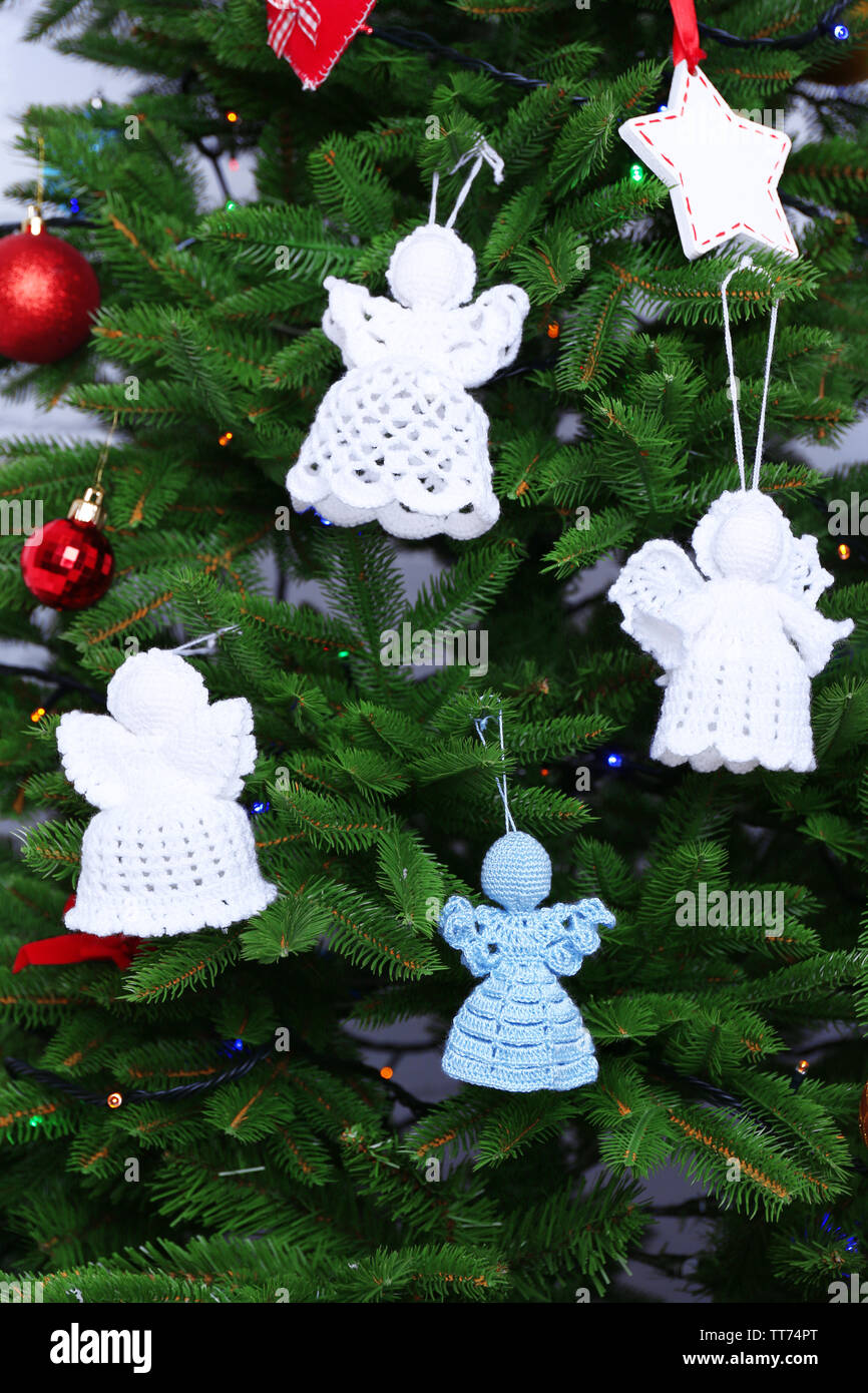 Knitted Christmas angels on Christmas tree, close-up Stock Photo ...