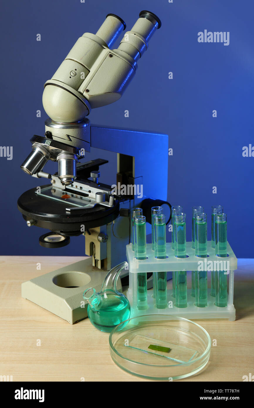 Microscope and test tubes on table, on color background Stock Photo - Alamy