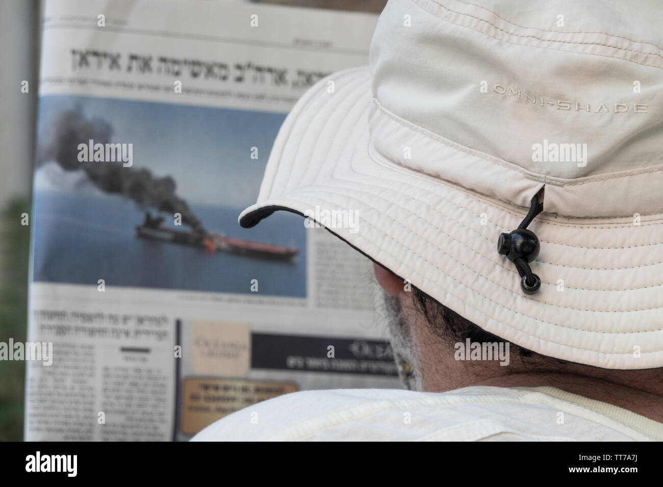 Jerusalem, Israel. 15th June, 2019. An Israeli reads a newspaper article dealing with the Gulf of Oman attack on oil tankers as Israel closely monitors the situation and possible consequences of US Iranian armed conflict. Credit: Nir Alon/ Alamy Live News. Stock Photo