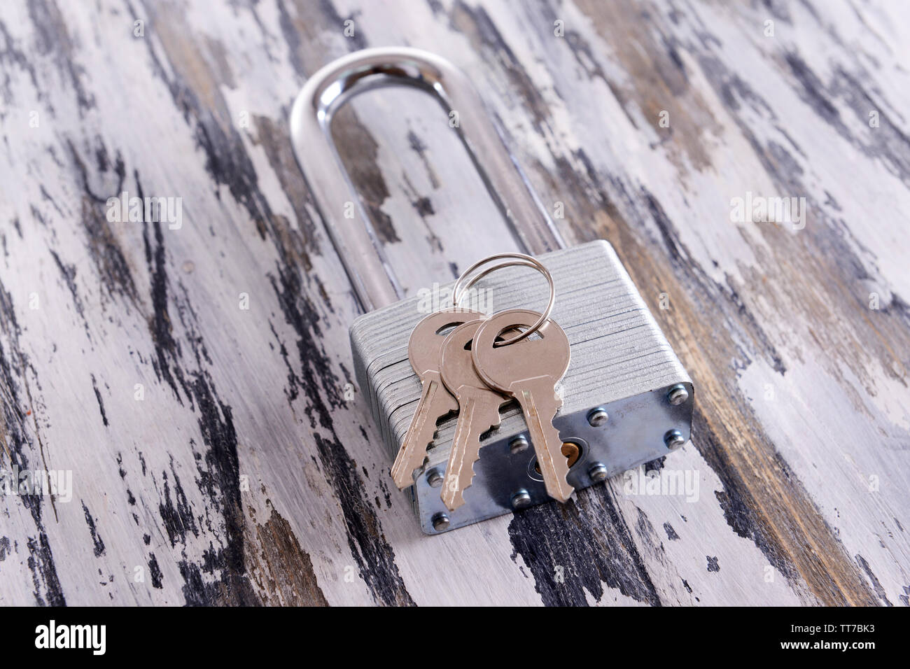 Padlock with keys on wooden background Stock Photo