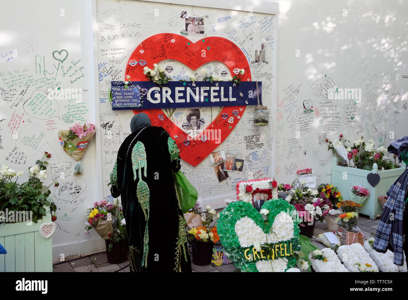 A woman leaving tributes for Grenfell tower victims, on the second anniversary of the tragedy. Stock Photo