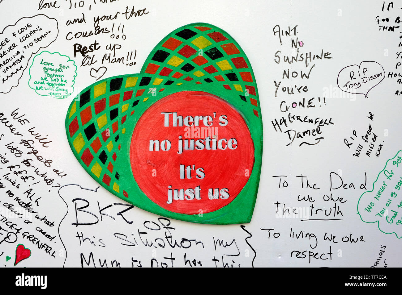 A heart shaped sign reading ' there is no justice, just us' left on a wall, to mark the second anniversary of Grenfell tragedy. Stock Photo